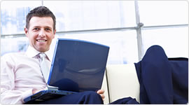 Guy smiling with laptop - We offer option trading, option trading services, low cost option trading, trade options, and trade options online