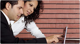 Man and woman looking at a laptop - We offer option trading, option trading services, low cost option trading, trade options, and trade options online
